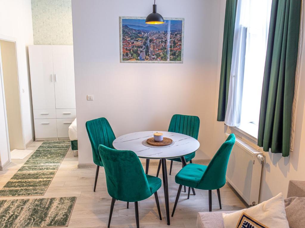 FIT Apartments في سراييفو: غرفة طعام مع طاولة وكراسي خضراء