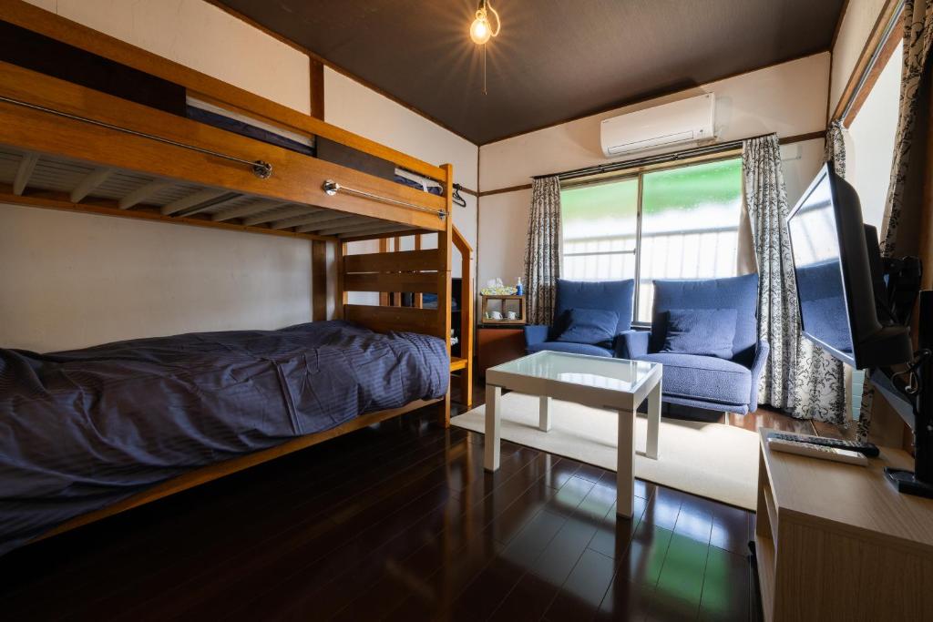 a bedroom with a bunk bed and a desk at Bed&Cafe Onzo オンゾー in Onomichi