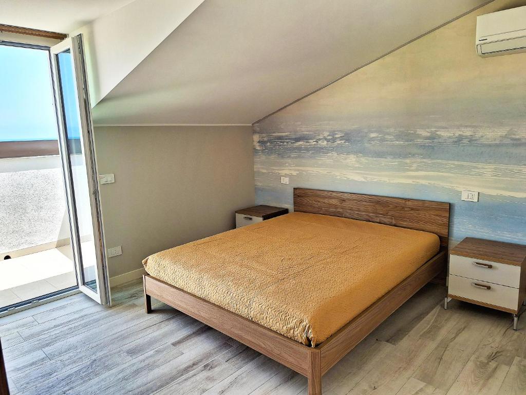 カステッランマーレ・デル・ゴルフォにあるCasa Vacanze Spiaggia Playaのベッドルーム1室(ベッド1台付)が備わります。壁には絵画が飾られています。