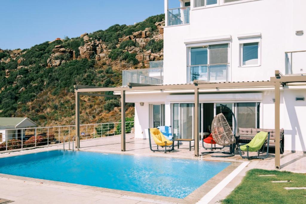 eine Villa mit einem Pool und einem Haus in der Unterkunft Chic Villa w Patio Pool 3 min to Beach in Bodrum in Gündoğan