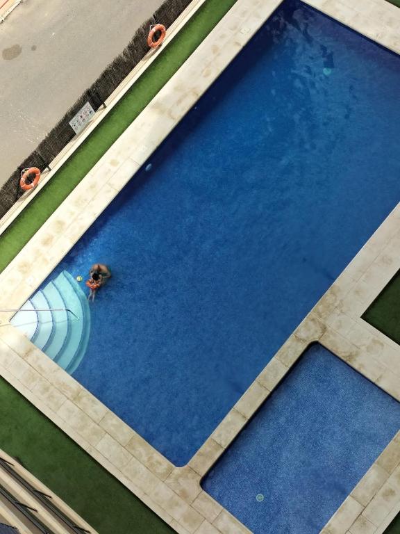einen Blick über einen Pool mit Taucher im Wasser in der Unterkunft Рядом с пляжем, тихое место in Alicante