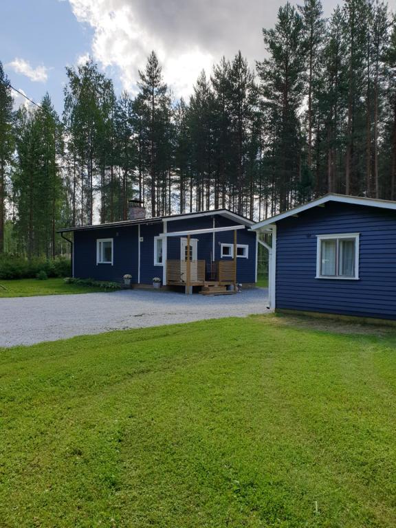 ein kleines blaues Haus mit einem großen Hof in der Unterkunft Simola in Pihtipudas