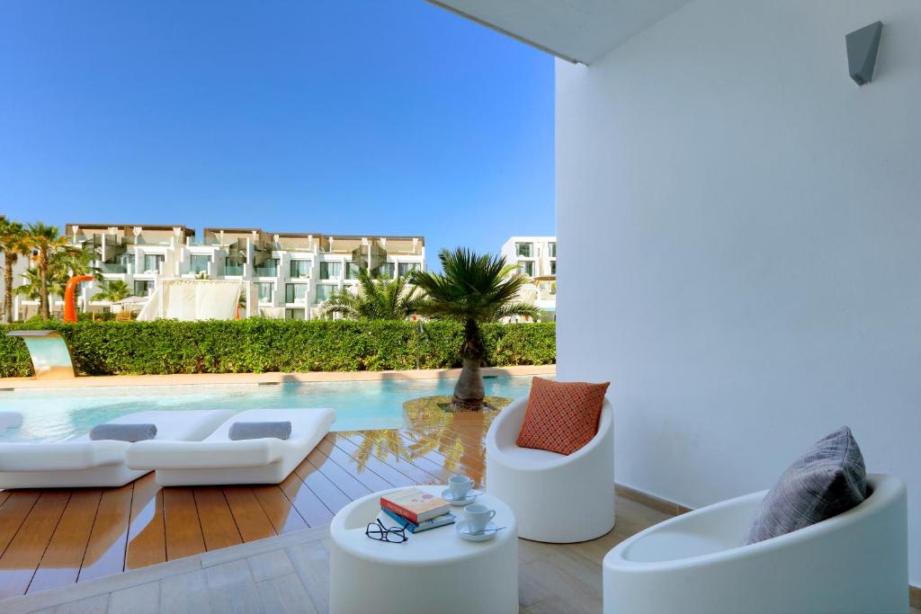 a living room with a swimming pool and a villa at Hard Rock Hotel Ibiza in Playa d'en Bossa