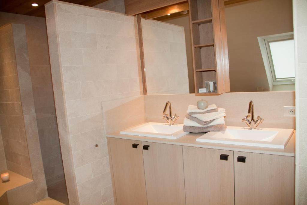 a bathroom with two sinks and a shower at B&amp;B - Ter Douve in Dranouter