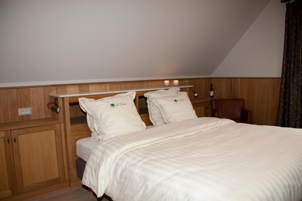 a bedroom with a bed with white sheets and pillows at B&amp;B - Ter Douve in Dranouter