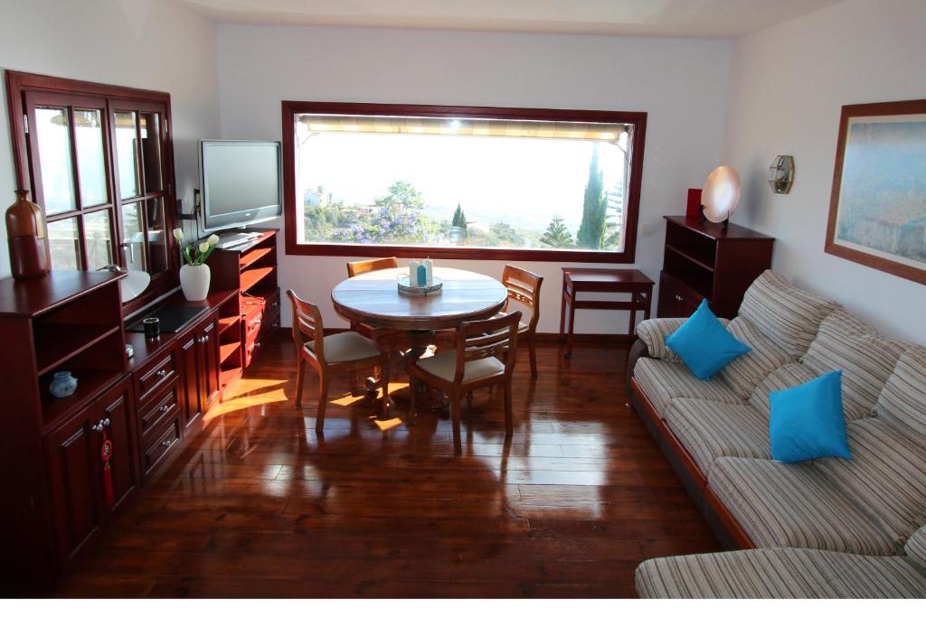 een woonkamer met een tafel en een bank bij ViVaTenerife - Retreat in nature, SPA and wellness in Tejina de Isora