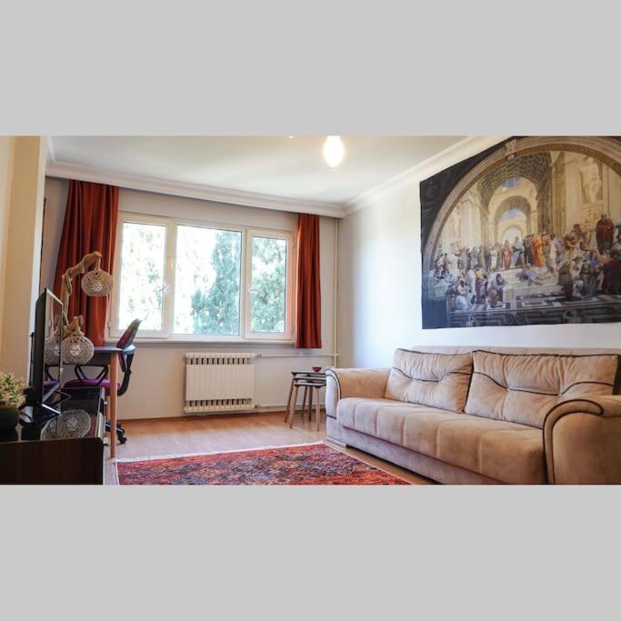 a living room with a couch and a painting on the wall at Sweet Flat For Sweet Famılies in Istanbul