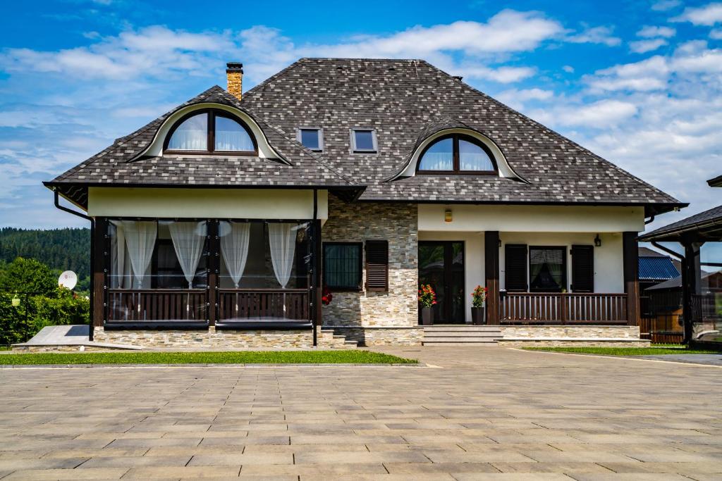 una casa con tetto di gambero e vialetto di Casa Românească a Putna