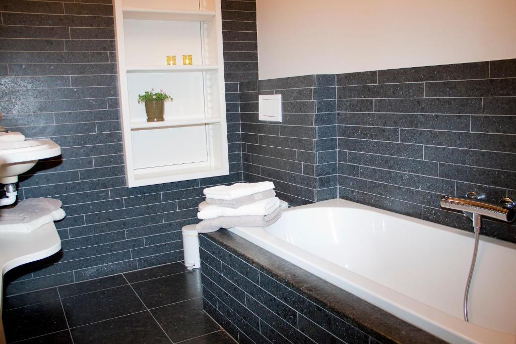 a bathroom with a bath tub and a sink at B&amp;B - Ter Douve in Dranouter