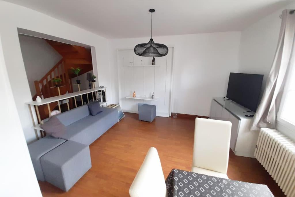 een woonkamer met een bank en een tv bij Bienvenue in Auxerre