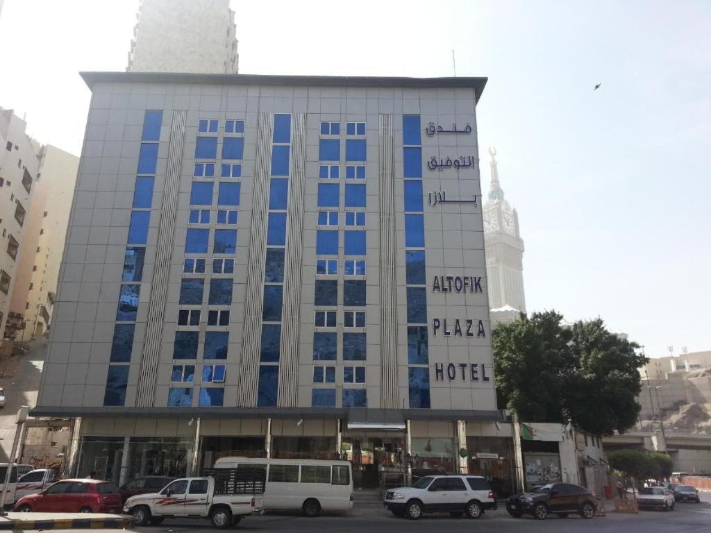 un gran edificio con coches estacionados frente a él en Al Tawfik Plaza, en La Meca