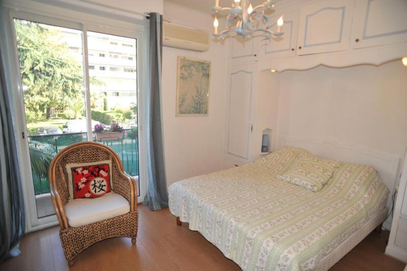 a bedroom with a bed and a chair and a window at Lavande de Croisette in Cannes