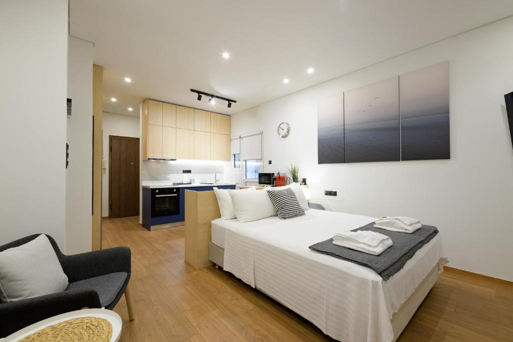 1 dormitorio con 1 cama blanca grande y cocina en Seaside Serenity: Charming Studio Flat, en Atenas