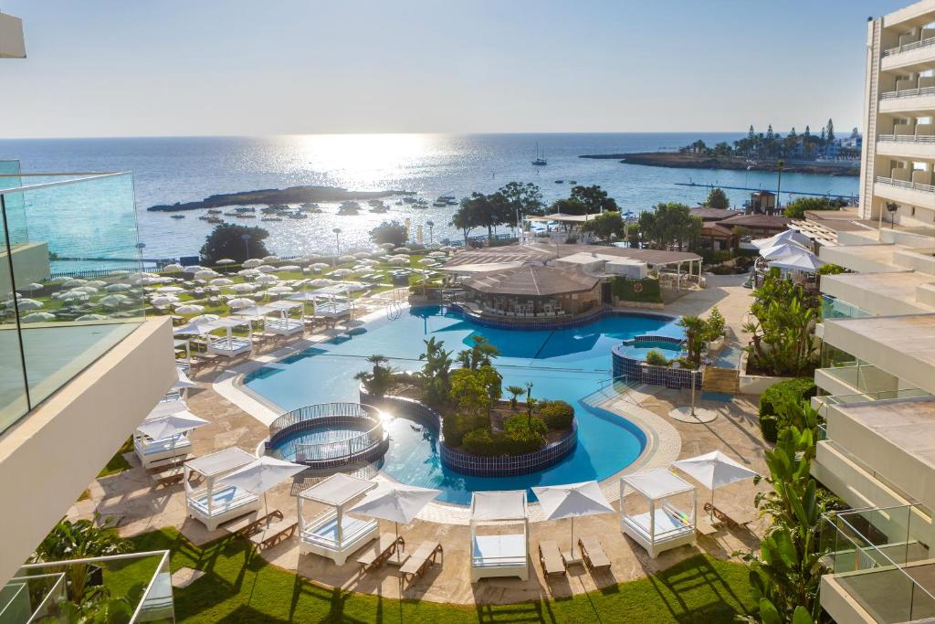 an aerial view of a resort with a pool and the ocean at Capo Bay Hotel in Protaras