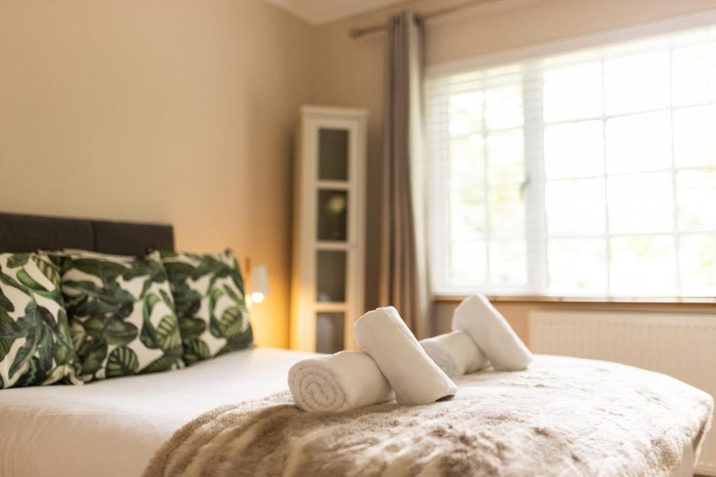 a bedroom with a bed with two towels on it at Romantic Cottage in Plymouth