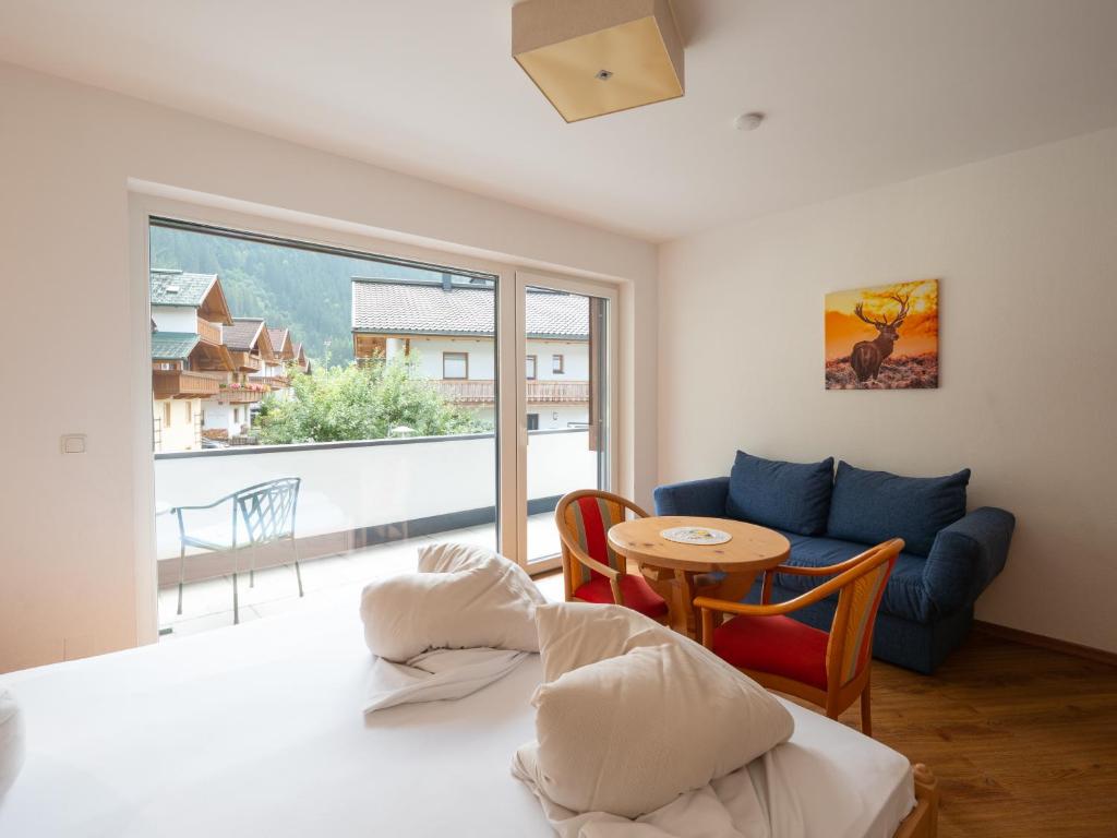 a room with a bed and a table and a couch at Appartement Perauer in Mayrhofen