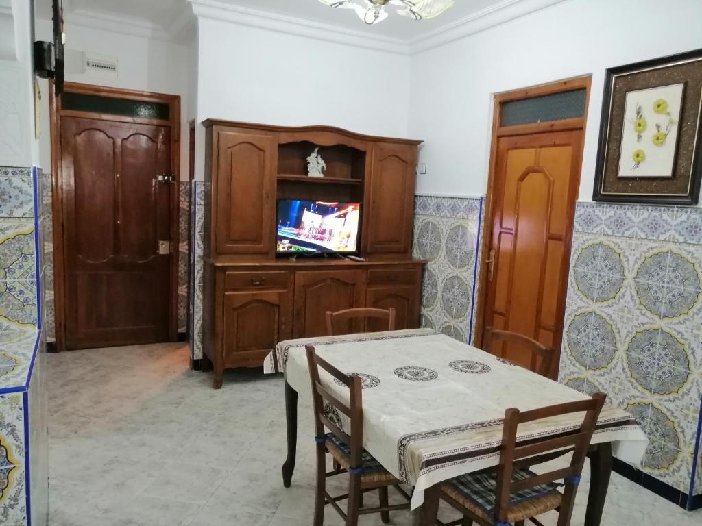 ein Esszimmer mit einem Tisch und einem TV in der Unterkunft المضيق الرينكون in Mʼdik