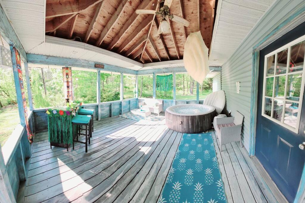 Experience The Serenity Of Pineapple Acre Pocono في سترودسبورغ: شاشة في الشرفة مع وجود طاولة وكراسي