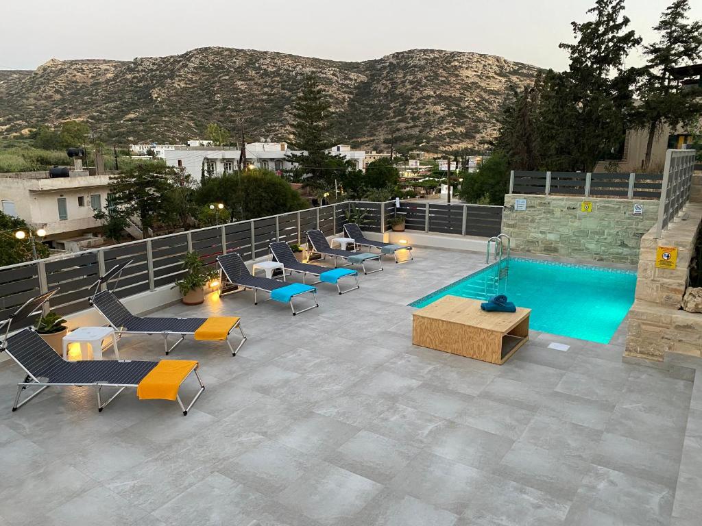 an outdoor patio with chairs and a swimming pool at Maistro Suites with pool, Matala in Matala