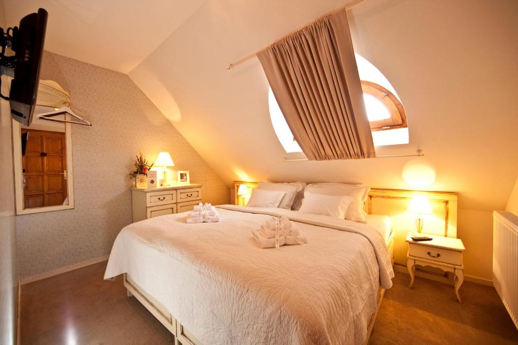 Postel nebo postele na pokoji v ubytování Rókusfalvy Borhotel és Fogadó