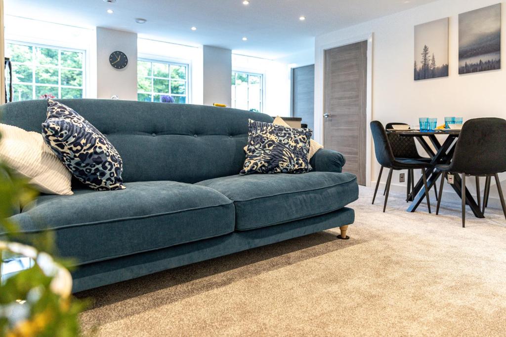 a blue couch in a living room with a table at Stylish & Contemporary 2-Bedroom House in Worksop