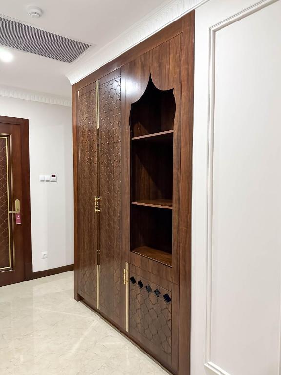 a wooden cabinet with a glass door in a room at Reikartz Sote Tashkent in Tashkent