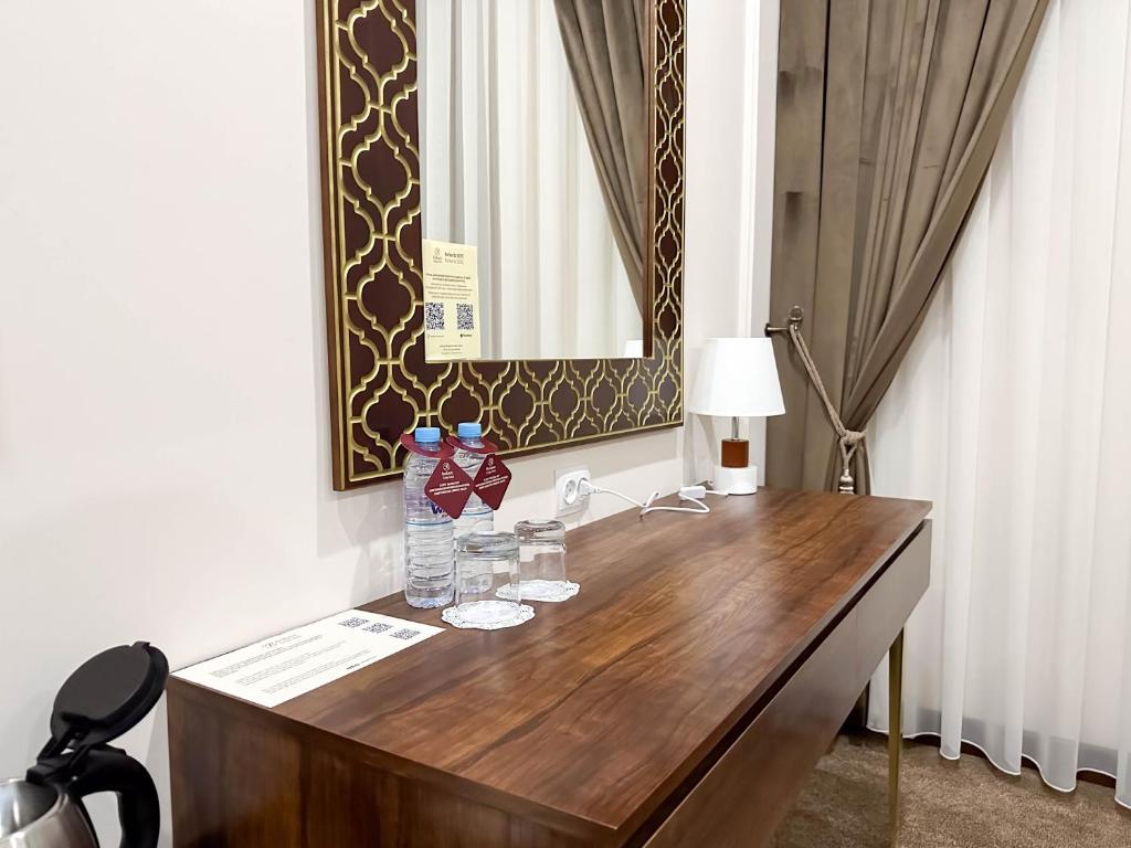 a bathroom with a wooden desk with a sink and a mirror at Reikartz Sote Tashkent in Tashkent