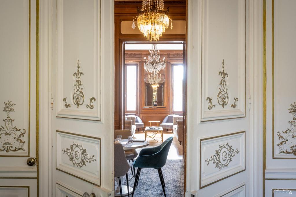 a hallway with a table and chairs and a chandelier at Le Champlain in La Rochelle