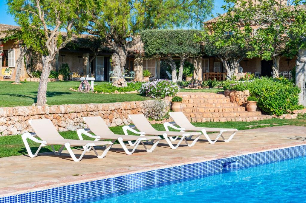 un grupo de tumbonas blancas junto a una piscina en Outstanding Finca RÚSTICA FELOSTAL with Sauna&Pool, en Son Ferriol