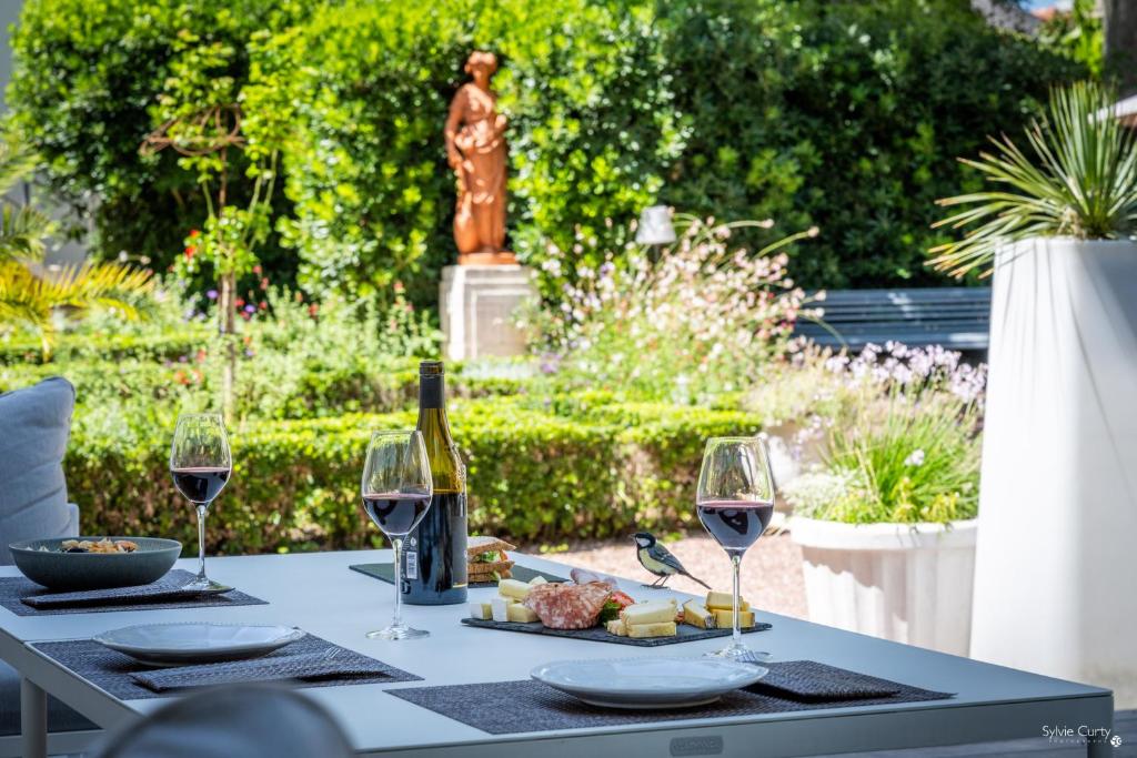 a table with wine glasses and cheese and a statue at Le Champlain in La Rochelle