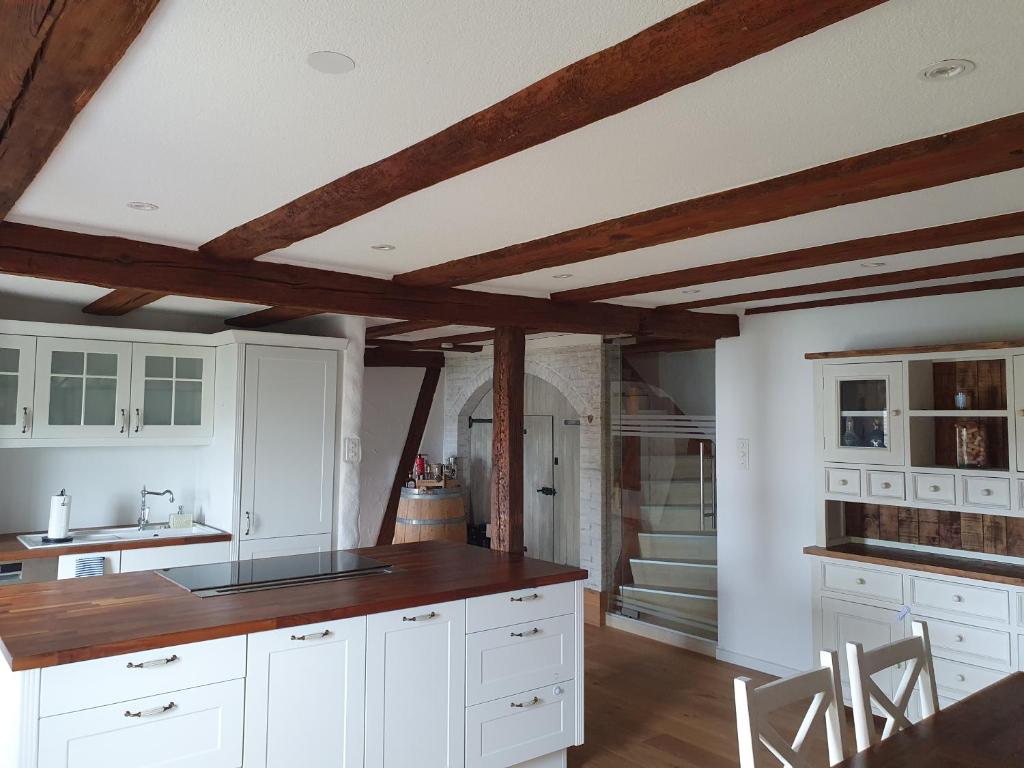 a kitchen with white cabinets and wooden ceilings at 3 Bedroom Swiss House on 3 Floors in Oberglatt