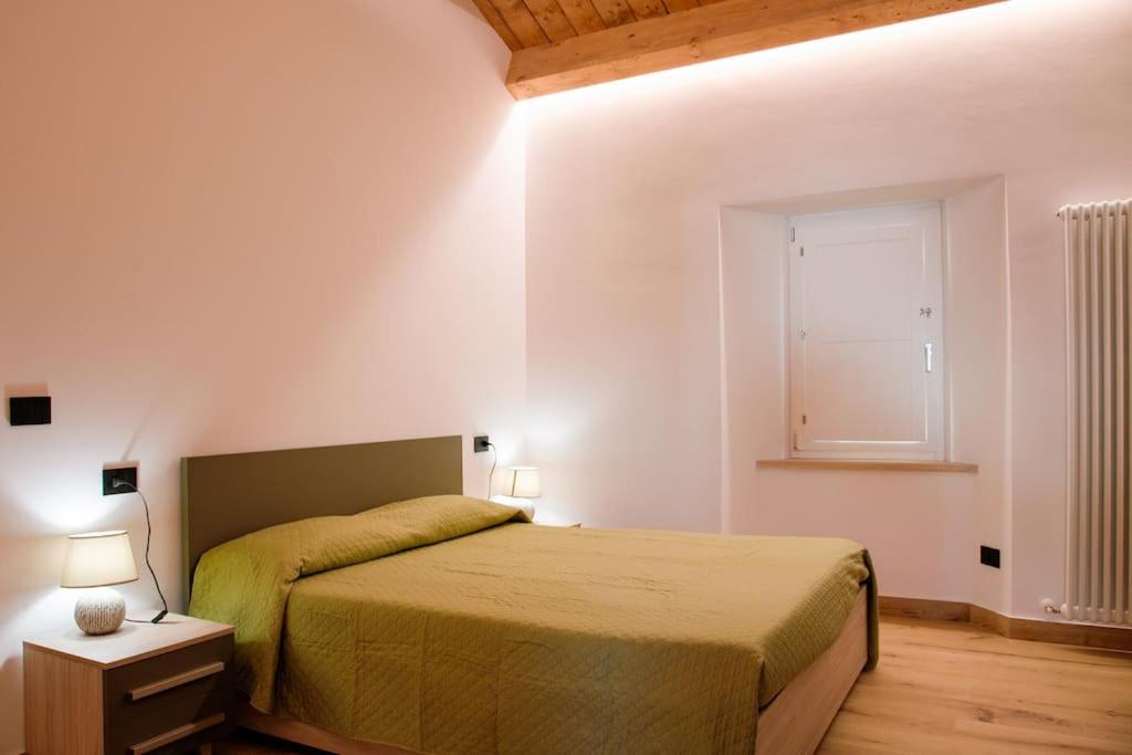 a bedroom with a large bed and a window at Tana a 5 STELLE in Capradosso