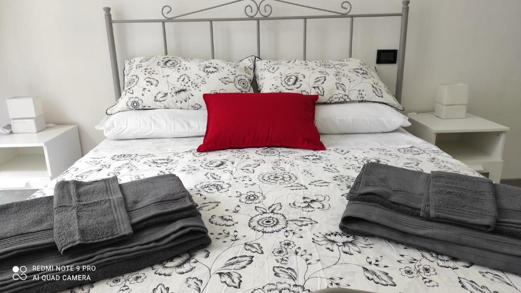 een bed met een rood kussen en kussens erop bij Giravolta (Jaco) in Sulmona