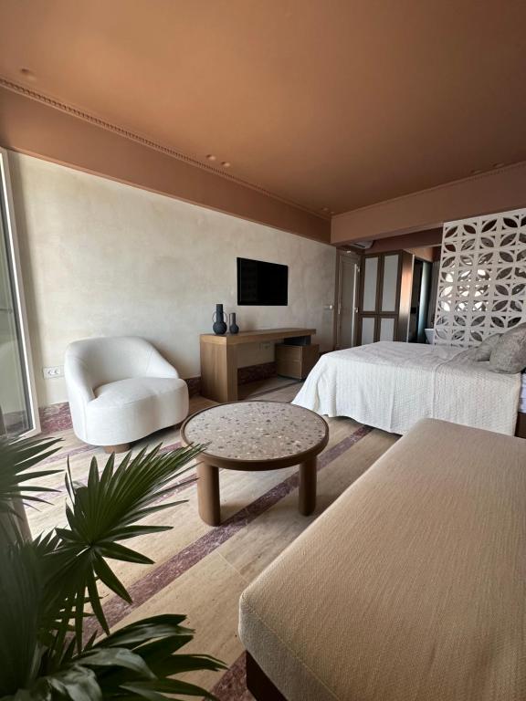 1 dormitorio con 2 camas, sofá y TV en Igisó, en Ermoupoli