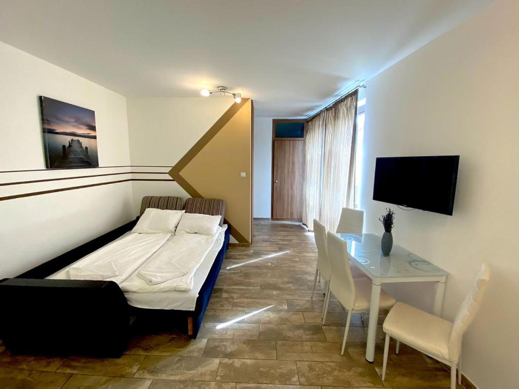 ハイドゥソボスローにあるArt Apartmentsのベッド、テーブル、椅子が備わる客室です。