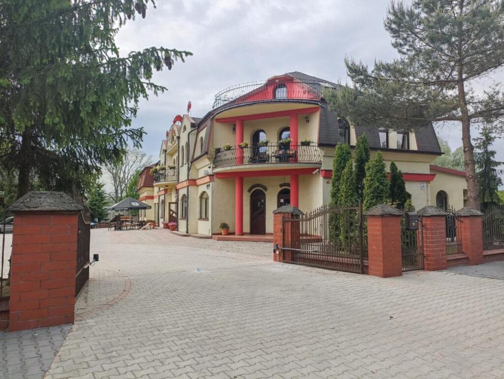 une grande maison avec une clôture devant elle dans l'établissement Zajazd Miechus, à Miechów
