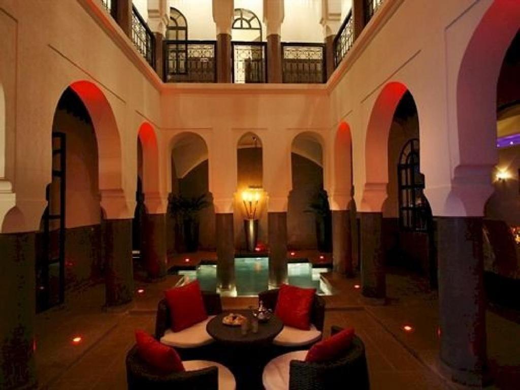 un hall avec une table et des chaises dans un bâtiment dans l'établissement Riad Carllian, à Marrakech