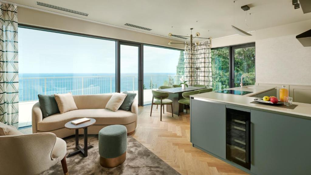 uma cozinha e sala de estar com um sofá e uma mesa em Maximilian Suites em Trieste