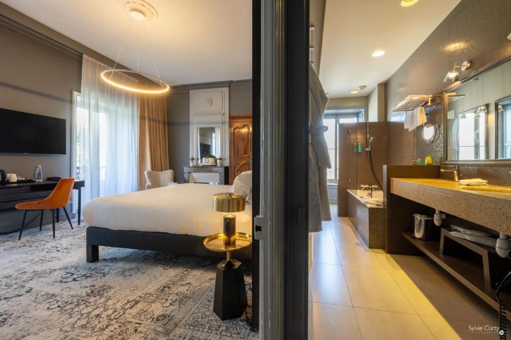 a hotel room with a bed and a bathroom at Le Champlain in La Rochelle