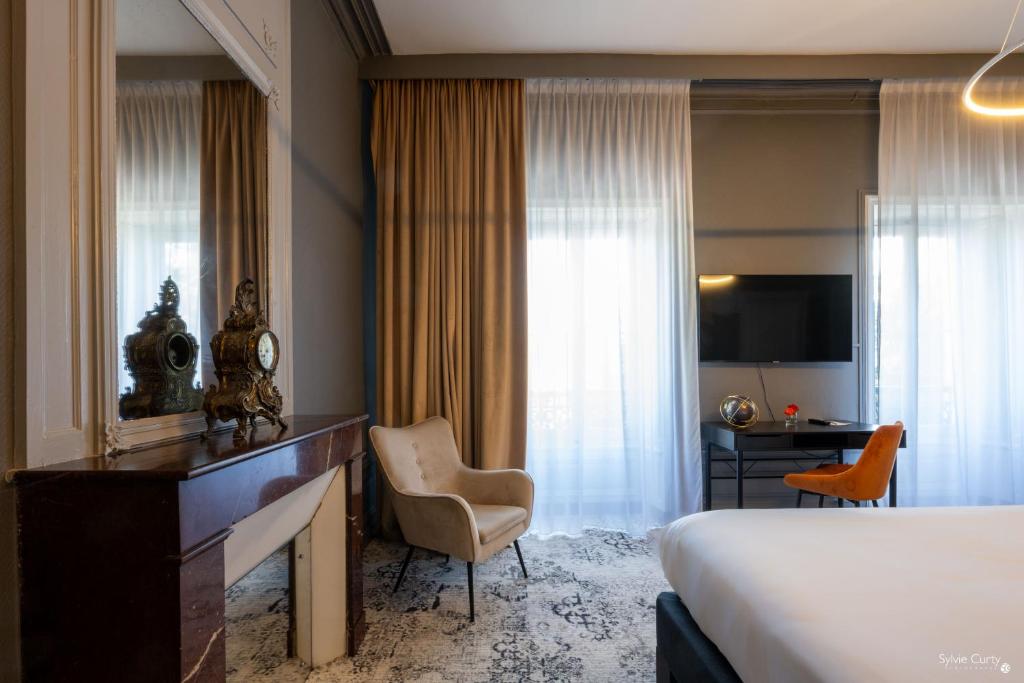 a hotel room with a bed and a desk and chair at Le Champlain in La Rochelle