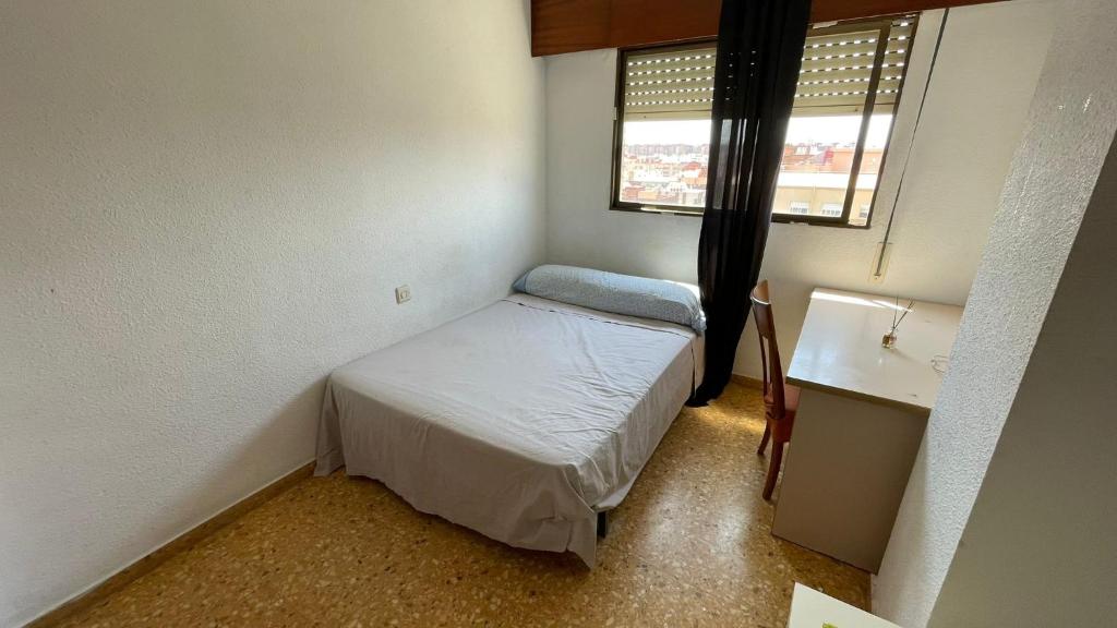 a small bedroom with a small bed and a window at flat Holiday friend group or family near beach center blasco ibanez in Valencia