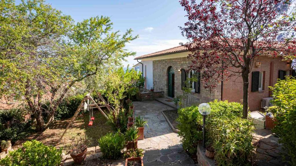 dom z ogrodem przed nim w obiekcie Villa con Giardino Vista Mare w mieście Castiglione della Pescaia