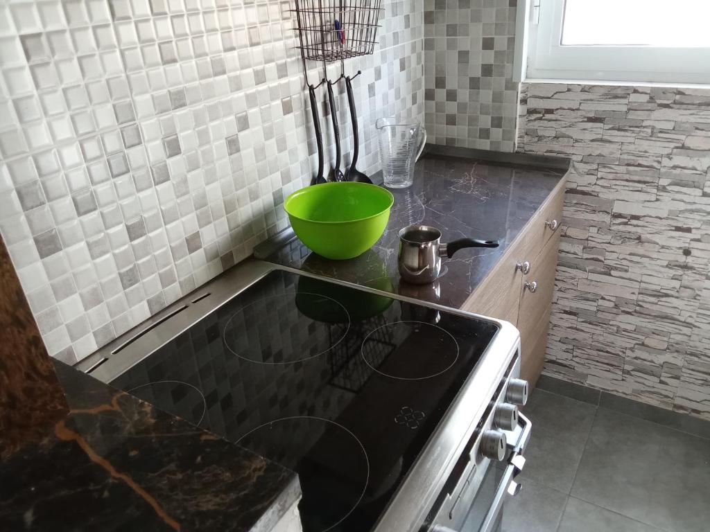 uma cozinha com fogão e uma tigela verde no balcão em Spacious apartment in center of Agia Napa em Agia Napa