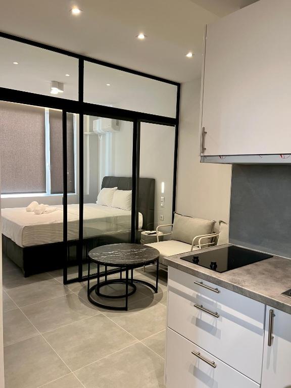 a room with a bed and a table and a kitchen at JV Athens in Athens