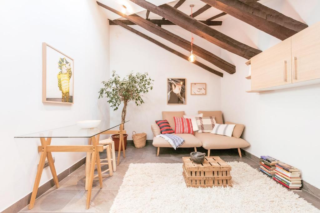 a living room with a table and a couch at Bohemian 2bedroom attic in Lavapies in Madrid