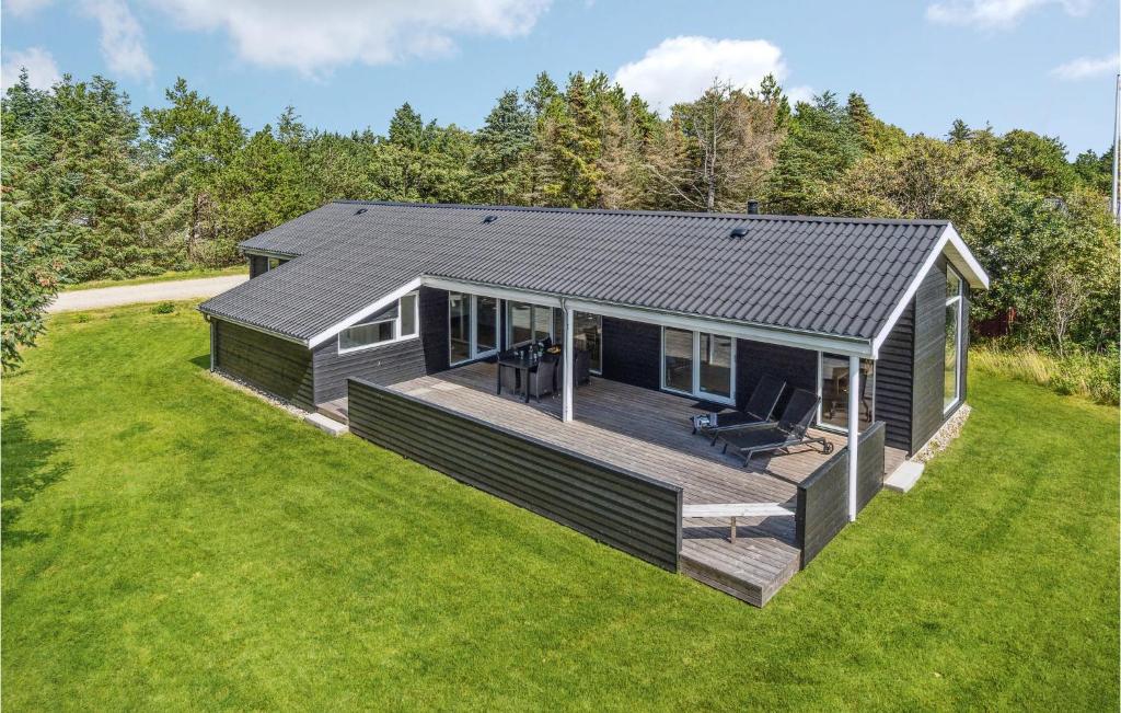 a small house with a deck in a yard at Holiday Home Karensvej in Grønhøj