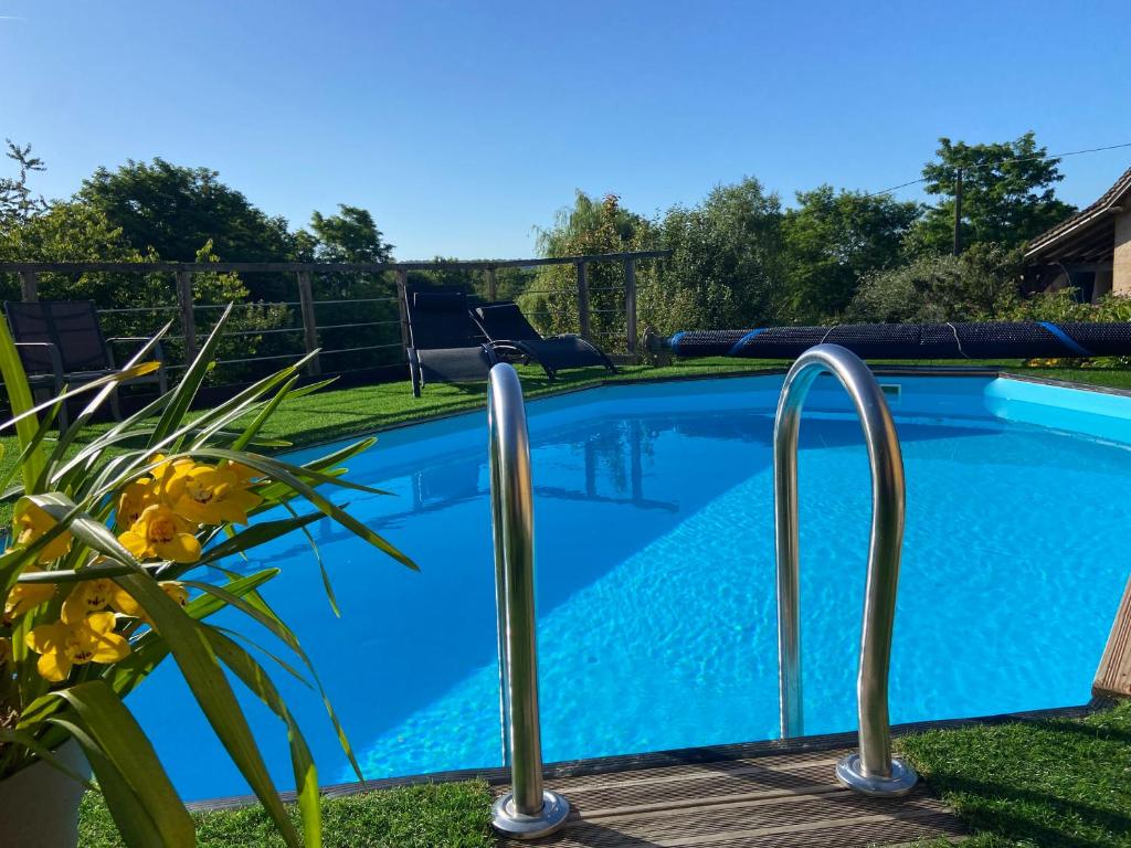 una piscina azul con barras de metal alrededor en Chambre d'Hôtes du Domaine de la Haute Poignandiere, en Saint-Germain-de-la-Coudre