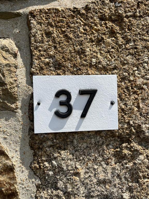 a sign with the number on a stone wall at Bienvenue chez Tom in Lamballe