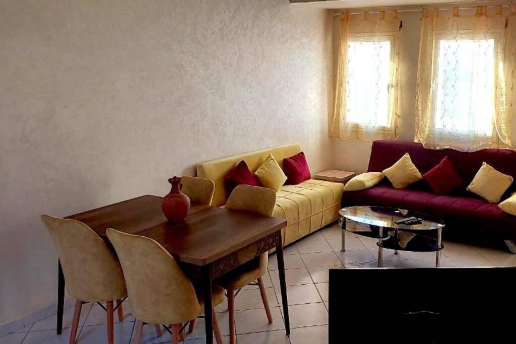 ein Wohnzimmer mit einem Sofa und einem Tisch in der Unterkunft Le jaune d'Ifni in Agadir