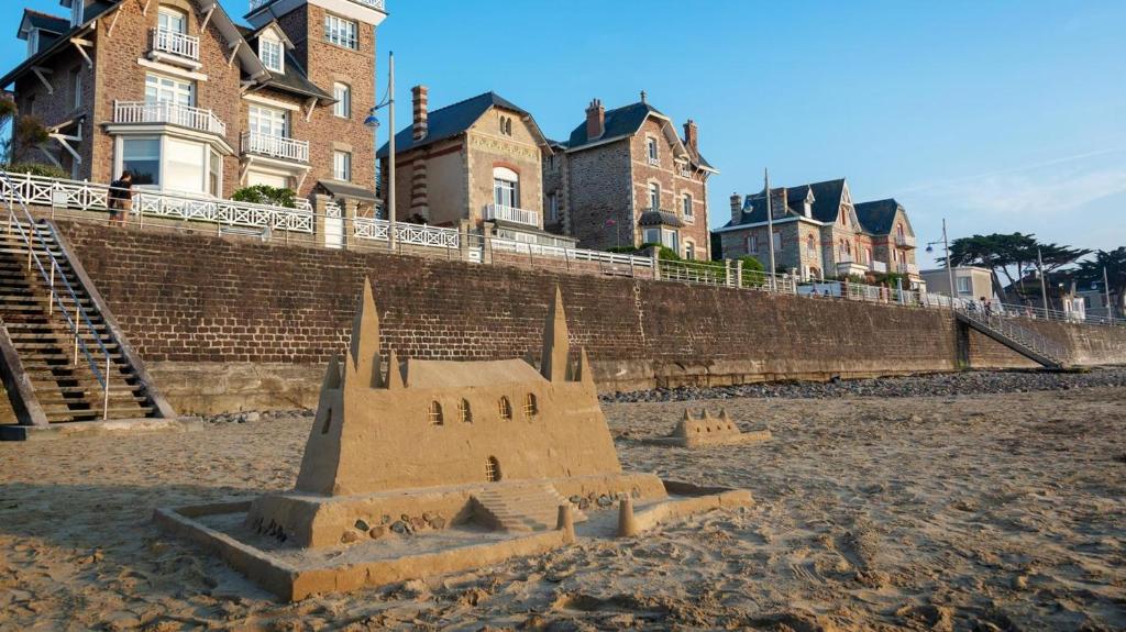 a sand castle on the beach in front of houses at Bienvenue chez Tom in Lamballe